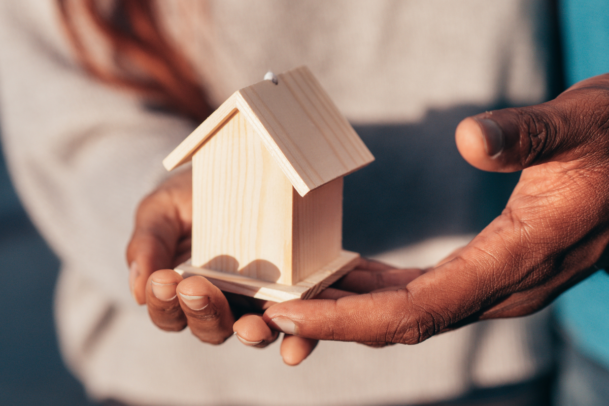 wooden model house in the hands of a person